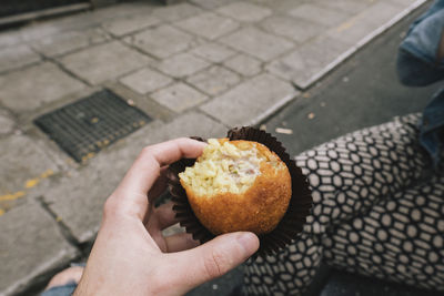 High angle view of hand holding ice cream on street