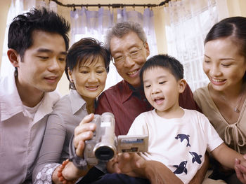 Family looking into video camera while sitting at home