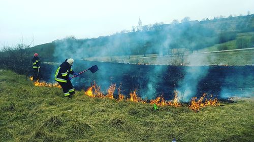 Firefighters by fire on field