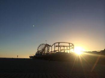 Silhouette amusement park during sunset