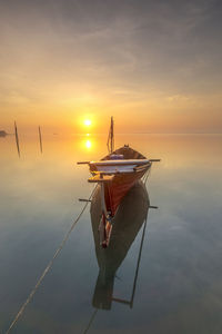 Boat on sea against sky during sunset