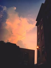 Low angle view of silhouette houses against sky during sunset