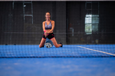 Portrait of beautiful woman playing padel tennis court indoor