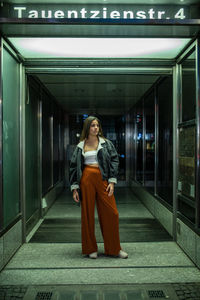 Full length of young woman standing in corridor