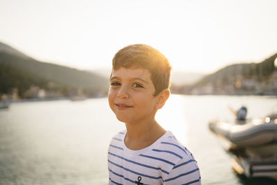 Portrait of boy smiling against sky