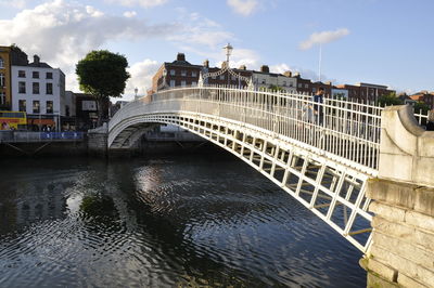 Bridge over river in city against sky