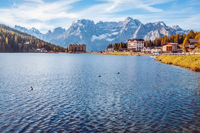 Scenic view of lake by buildings against sky