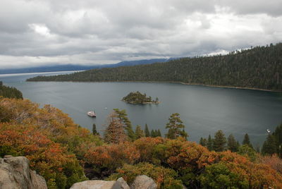 Scenic view of lake by trees against sky