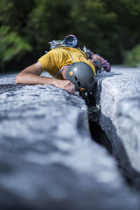 Man placing protection while climbing wide crack on granite squamish