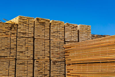 Low angle view of stack of building against clear blue sky