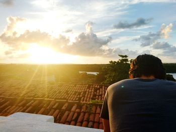 Rear view of woman against sky during sunset