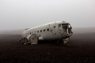 Abandoned airplane on land during foggy weather