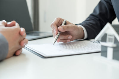 Midsection of man using mobile phone on table