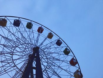 Low angle view of ferris wheel against clear blue sky