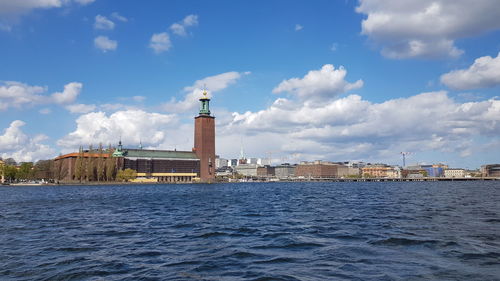 Buildings in city against cloudy sky