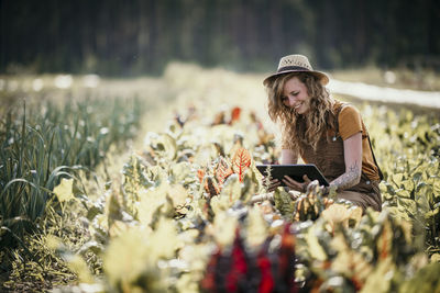 Young woman using mobile phone on field