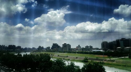 River in city against cloudy sky