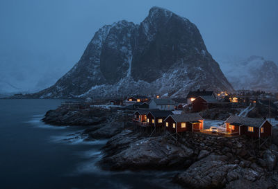 View of lake and town against mountains during winter