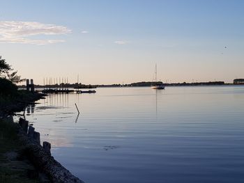 Sailboats in sea against sky during sunset