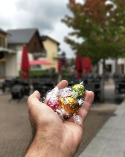 Midsection of person holding ice cream in city