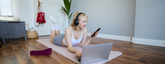 Portrait of young woman using mobile phone at home