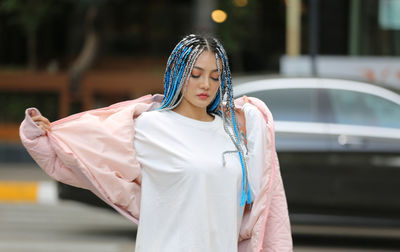 Beautiful woman with dreadlocks standing on road