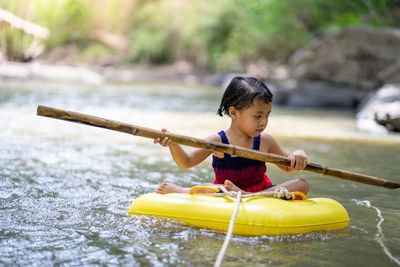 Active little girl playing at mountain stream