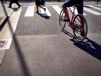 Low section of man with bicycle on road