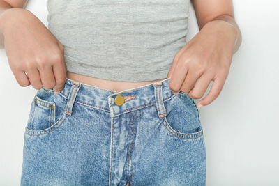 Midsection of woman standing against white background