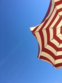 Low angle view of flags against clear blue sky