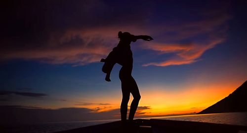 Silhouette man standing against sky during sunset