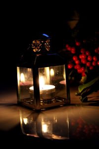 Close-up of lit candle in darkroom