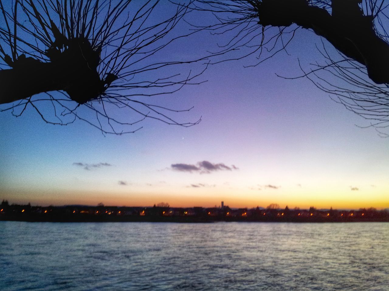 water, silhouette, waterfront, sunset, sky, scenics, tranquility, tranquil scene, tree, beauty in nature, dusk, nature, lake, bare tree, river, reflection, idyllic, sea, illuminated, outdoors