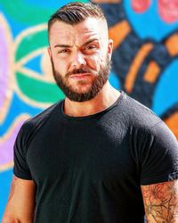 Portrait of young man standing against wall