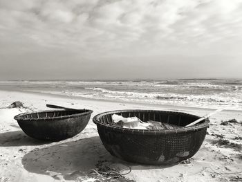 Close-up of bowl on beach against sky