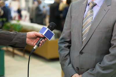 Close-up of man holding camera while standing outdoors