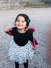 Portrait of smiling girl standing outdoors