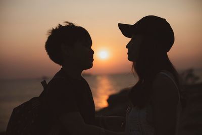 Silhouette couple against sea during sunset