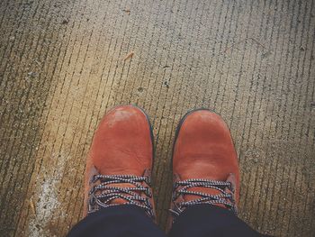 Low section of man wearing orange shoes on road