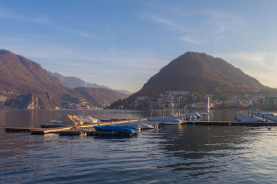 Boats in sea against mountain