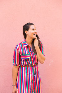 Happy woman looking away against wall