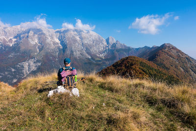 Rear view of backpacker looking at mountain range