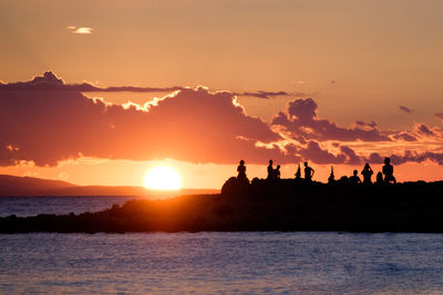 Silhouette of people on beach during sunset