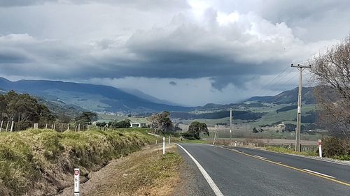 Empty road with mountain range in background