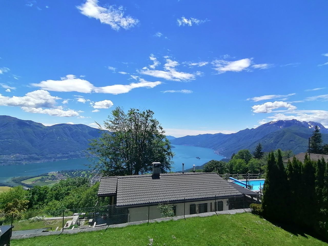 TREES AND HOUSES AGAINST MOUNTAINS