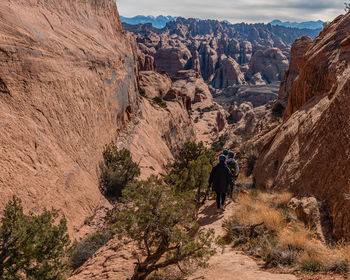 People hiking in rugged terrain around moab with sandstone formations to explore