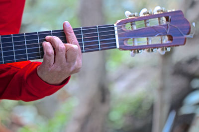 Midsection of man playing guitar