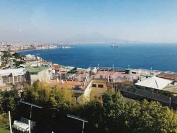 High angle view of townscape by sea against sky