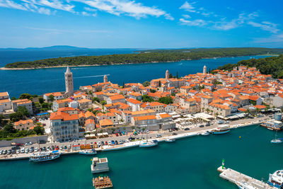 High angle view of townscape by sea against sky