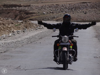 Rear view of man riding bicycle on road